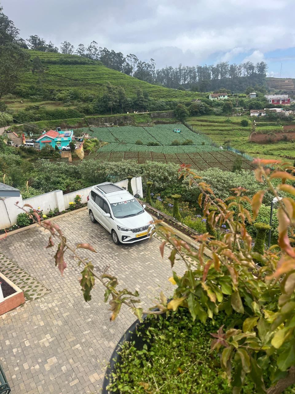 Cab on a winding road through terraced farms in the Nilgiris